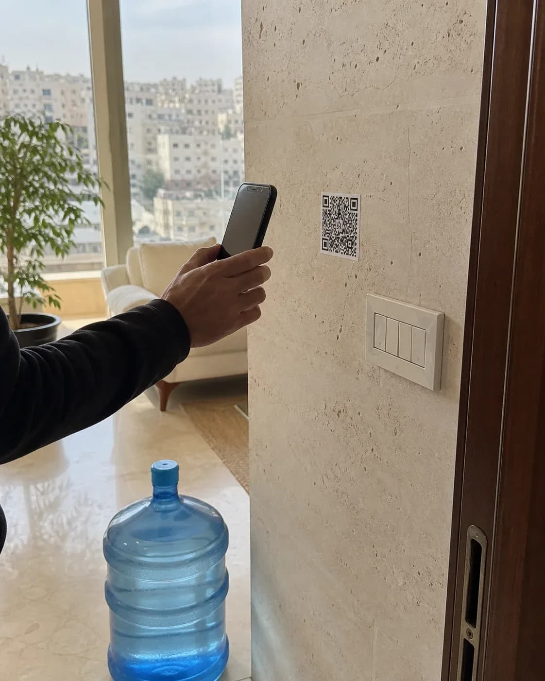 A Deliveryy QR sticker being scanned beside a water bottle.